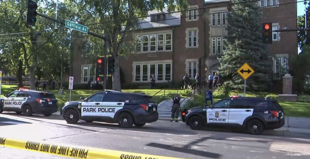 View of Annunciation School and church with multiple police cars and officers outside.